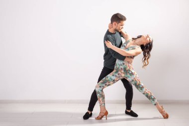 Sosyal dans, Bachata, salsa, Kizomba, Zouk, Tango kavramı-adam kucaklamak kadın kopya alanı ile beyaz arka plan üzerinde dans ederken