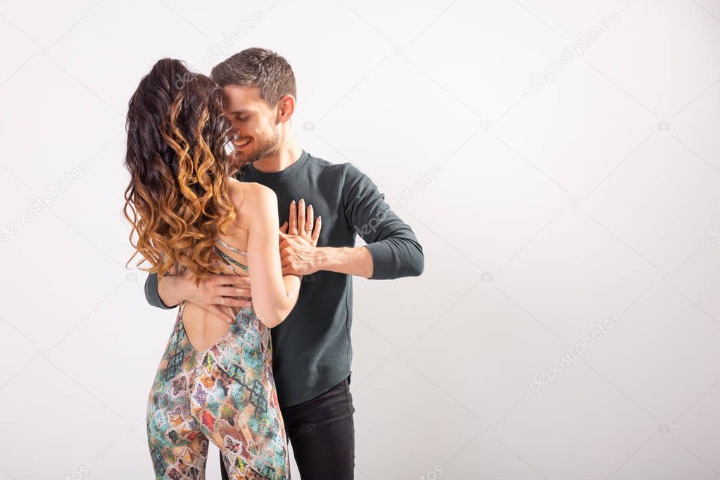 Social dance concept - Active happy adults dancing bachata or tango together over white background with copy space