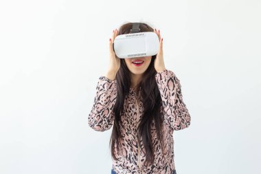 Sanal gerçeklik gözlüğü takan ve kopya alanı ile beyaz bir arka plan karşı dururken bir oyun oynarken güzel genç kadın. Fütürizm ve yeni teknolojiler kavramı.
