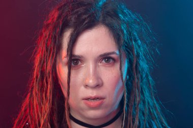 Stil, gençlik, insanlar kavramı-Dreadlock ile genç neşeli kadın karanlık arka planda rocker gibi görünüyor