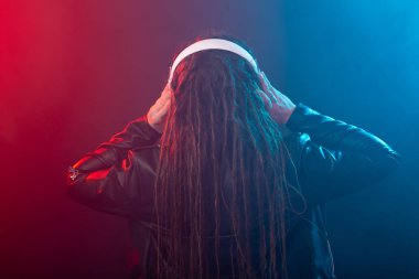Meloman, müzik ve insan kavramı-dreadlocks ile genç kadın müzik dinlemek ve zevk, arka görünüm