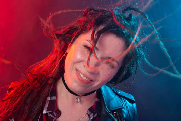 Młodzież, fryzura i nowoczesna koncepcja-młoda kobieta z dredy uśmiechnięta i zabawy na czerwonym i niebieskim tle światła — Zdjęcie stockowe