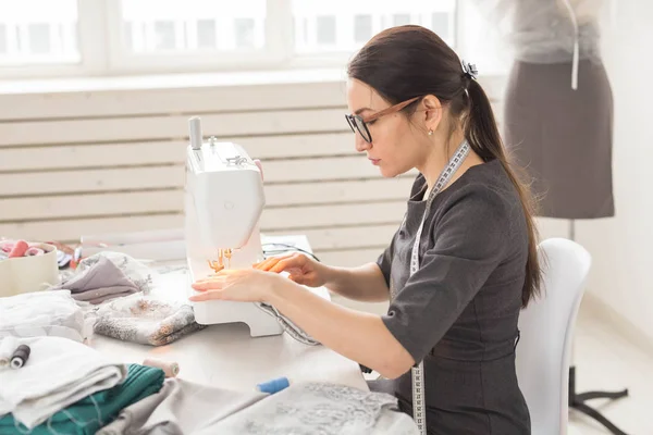 Dressmaker, sastre y concepto creativo - Retrato del diseñador de moda con máquina de coser sobre fondo blanco — Foto de Stock