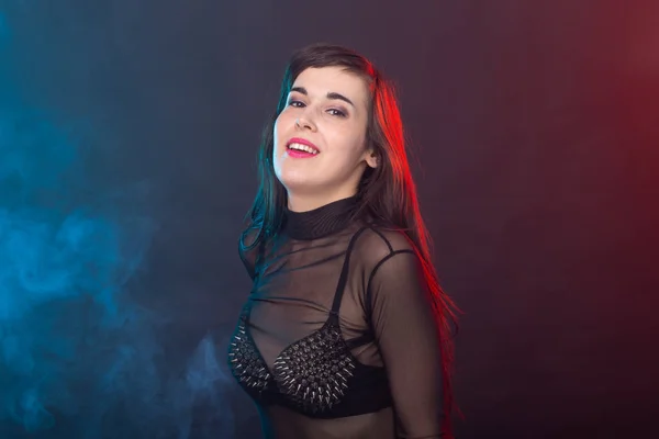 Verführerische junge schöne brünette Frau in einem provokanten Kleid posiert auf einem dunklen Hintergrund. Konzept der Verführung und sexuellen Attraktivität. — Stockfoto