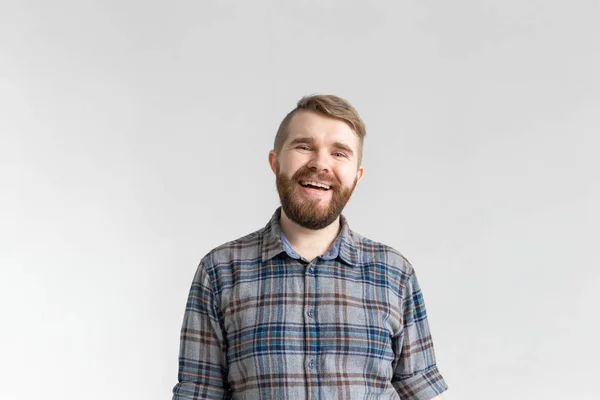 Bonito homem barbudo feliz sorrindo e rindo no fundo branco com espaço de cópia — Fotografia de Stock