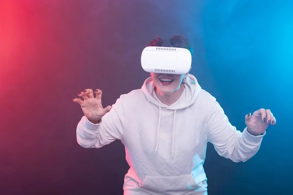 Mujer de mediana edad con gafas de realidad virtual. Captura de estudio, fondo rojo-azul —  Fotos de Stock