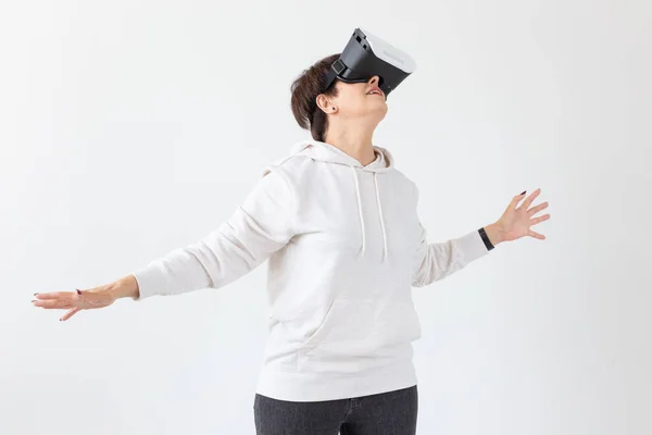 Modern technologies, future and people concept - Woman 40-50 years old wearing virtual reality glasses on white background