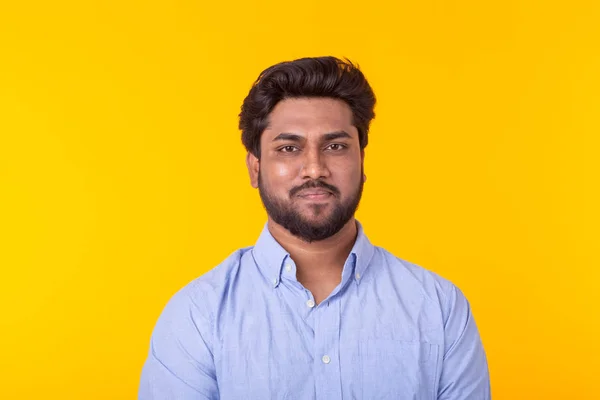 Indiano bonito homem vestindo camisa azul no fundo amarelo — Fotografia de Stock