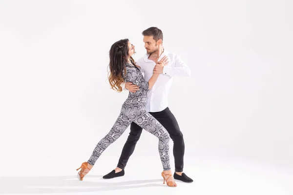 Dança social, bachata, kizomba, zouk, conceito de tango - Homem abraça mulher enquanto dança sobre fundo branco com espaço de cópia — Fotografia de Stock