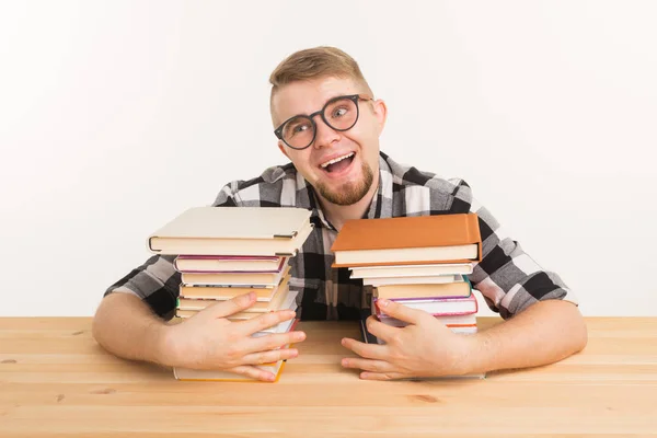 Persone, conoscenza e concetto di istruzione - Felice divertente studente vestito con camicia a quadri seduto al tavolo di legno con libri — Foto Stock