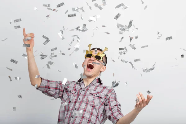 Gente, vacaciones y concepto de fiesta - Hombre con cara divertida en camisa a cuadros con confeti — Foto de Stock