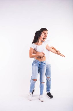 Genç çift sosyal dans dans bachata, merengue, salsa, kizomba. Beyaz Oda üzerinde iki zerafet poz.