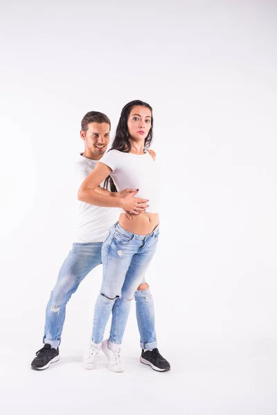 Jong koppel sociale dansen dansen merengue, salsa, bachata, kizomba. Twee elegantie pose op de witte kamer. — Stockfoto