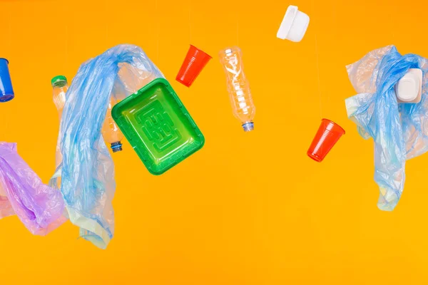 Inquinamento ambientale, problema del riciclaggio della plastica e concetto di problema ecologico - diversi rifiuti di plastica su sfondo giallo . — Foto Stock