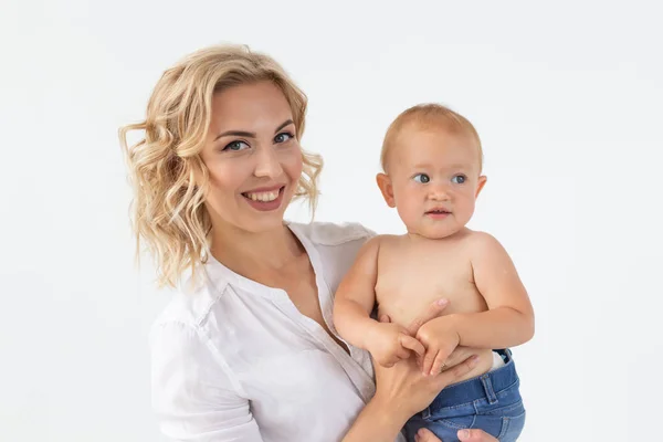 Tek ebeveyn, annelik ve bebeklik kavramı - Anne beyaz arka plan üzerinde tatlı bebek kız tutan — Stok fotoğraf