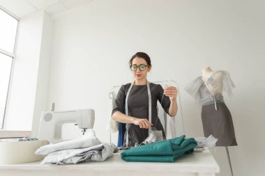 Terzi, moda tasarımcısı, terzi ve insanlar kavramı - iş yerinde bir kadın terzi portresi