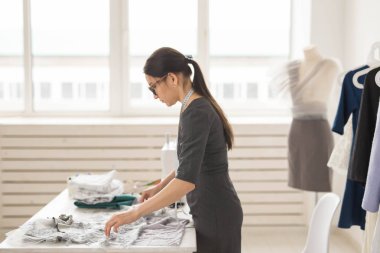 Terzi, moda tasarımcısı ve terzi kavramı - genç kadın tasarımcı, bir elbise yaratma süreci