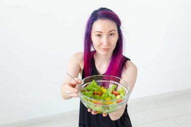 Evinde bir egzersiz sonrası hafif sebze salatası yiyen genç bir Asya hipster kız üst görünümü. Kilo verme kavramı ve sağlıklı yaşam tarzı.