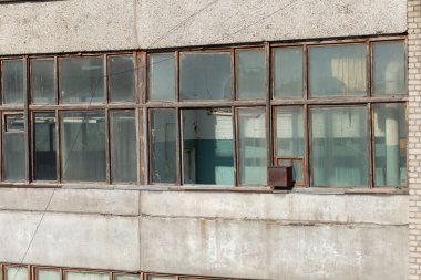 Atölye salonundaki büyük pencereler inşaat fabrikasını terk etti.