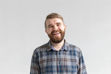 Yakışıklı genç sakallı adam gülümseyen ve beyaz arka plan üzerinde gülüyor