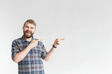 Beyaz bir arka plan üzerinde poz ve sağ işaret bıyıklı Mutlu komik genç hipster adam. Sürpriz kavramı ve reklam ve bağlantılar için bir yer
