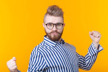 İnsanlar, duygular ve zafer kavramı - Sarı arka plan üzerinde yumrukgösteren gömlek giymiş heyecanlı ve mutlu genç adam.