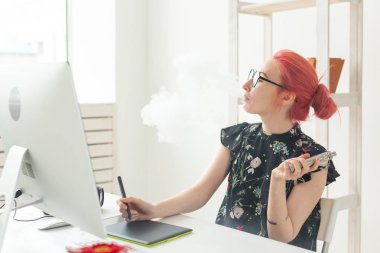 grafik tasarımcı kavramı - Kadın grafik tasarımcı ofiste masada grafik tablet kullanırken bilgisayar üzerinde çalışan ve bir vape sigara