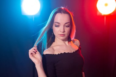 Gece kulübü, gece hayatı ve insan konsepti-karanlıkta poz veren genç kadın