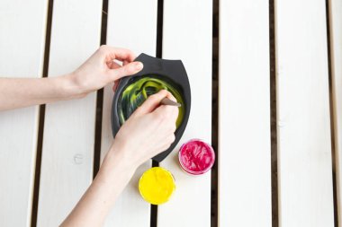 Boyama ve saç stilisti kavramı - kuaför elleri saç için bir renk karıştırma, üst görünümü