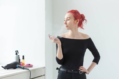 Vape, bağımlılık ve insan kavramı - renkli saçlı genç kadın bir vape sigara