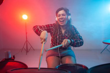 Müzik, davul ve hobi konsepti - genç kadın kulüpte elektronik davul seti çalıyor