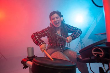 Duygular, müzik ve hobi konsepti - elektronik davul seti çalan genç kadın müzisyen