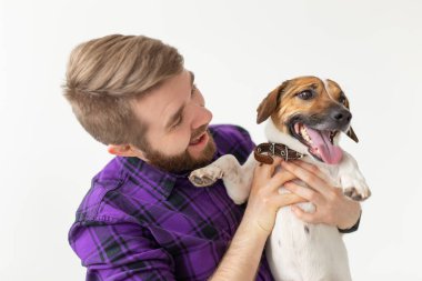 Hayvan, evcil hayvan ve insan kavramı - Beyaz arka plan üzerinde onun küçük jack russell terrier köpek tutarak Gülümseyen mutlu adam