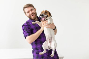 Hayvan, evcil hayvan ve insan kavramı - Gülümseyen mutlu adam kopya alanı ile beyaz arka plan üzerinde onun küçük jack russell terrier köpek tutarak