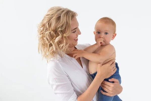 Conceito de família, maternidade e família - Mãe jovem segurando seu bebê em fundo branco — Fotografia de Stock