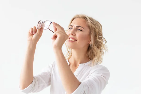 Visión, óptica y belleza - Joven rubia que se pone un par de gafas sobre fondo blanco —  Fotos de Stock