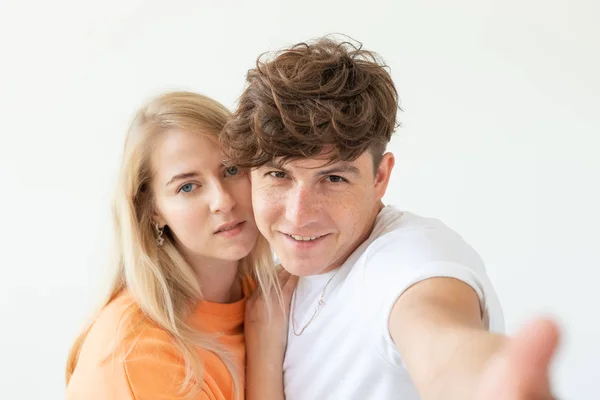 Porträt eines netten, positiv gestimmten jungen Studentenpaares, das ein Selfie mit einem Smartphone oder einer Kamera macht. das Konzept eines leidenschaftlichen jungen Paares, das sich in Studenten verliebt. — Stockfoto