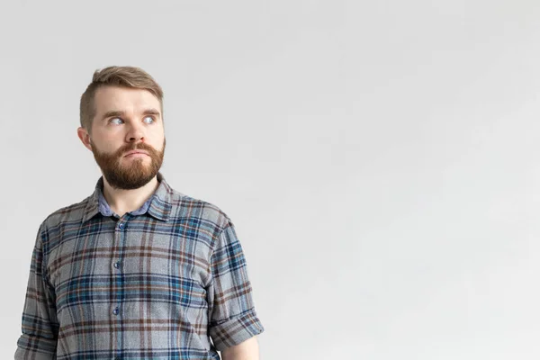 Bonito homem fazendo olhos abaulados de surpresa contra um fundo branco com espaço de cópia. Conceito de surpresa e incerteza . — Fotografia de Stock