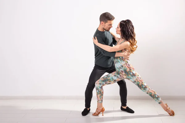 Dança social, bachata, kizomba, tango, salsa, conceito de pessoas - Casal jovem dançando sobre fundo branco com espaço de cópia — Fotografia de Stock