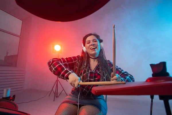電子ドラムセット、音楽と趣味のコンセプト - ヘッドフォンで演奏若い女性ドラマー — ストック写真