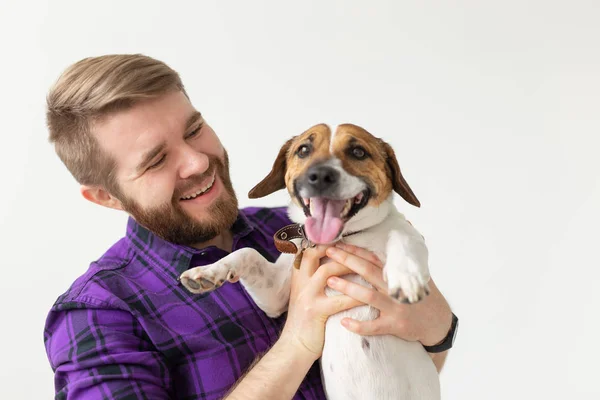 ペットの所有者の概念 - 白い背景に子犬と遊ぶ若い男 — ストック写真