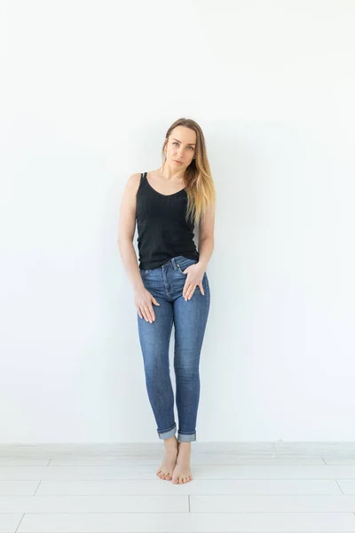 风格，人的概念 - 年轻女子在牛仔裤和黑色衬衫站在白色背景 — 图库照片