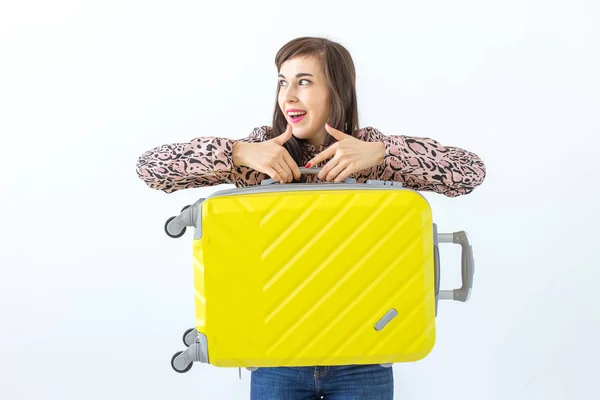 Joven morena sonriente alegre posando con una maleta amarilla mientras espera unas vacaciones. El concepto de turismo y viajes — Foto de Stock