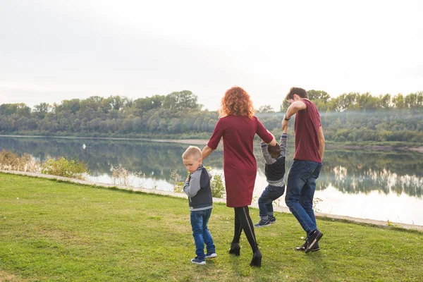 Childhood and nature concept - Family walking by the water — Stock Photo, Image