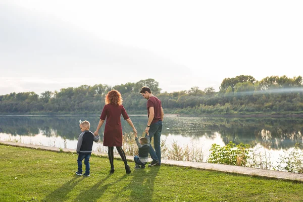 Childhood and nature concept - Family walking by the water — Stock Photo, Image