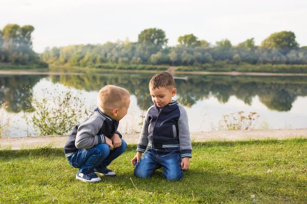 Kinder, Kindheit, Menschen Konzept - Kinder Jungen spielen am Strand in der Nähe des Flusses — Stockfoto