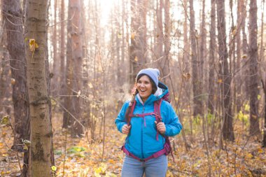 İnsanlar, yürüyüş ve doğa kavramı - giyimli kadın mavi ceketli ormanda yürüyüş