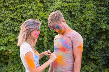 Dostluk, festival Holi - holi Festivali genç adamın kirli t-shirt ile genç kadın oyun