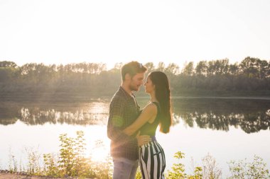 Romantik ve insanlar kavramı - birlikte nehir ya da göl sarılma ve yaz vaktinizi genç Çift