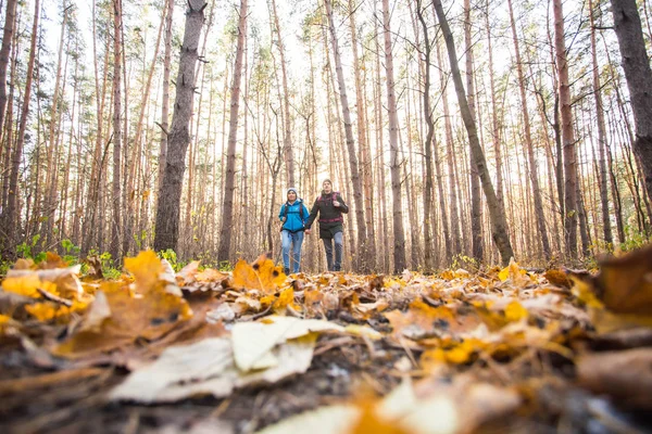 Dobrodružství, cestování, Turistika, výlet a lidé koncept - mladý pár s batohy v lese — Stock fotografie